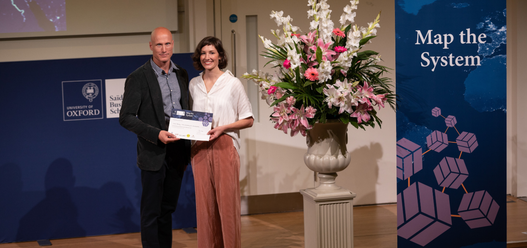 Dr. Abbey Eeles, University of Melbourne holding Map the System 2018 prize award