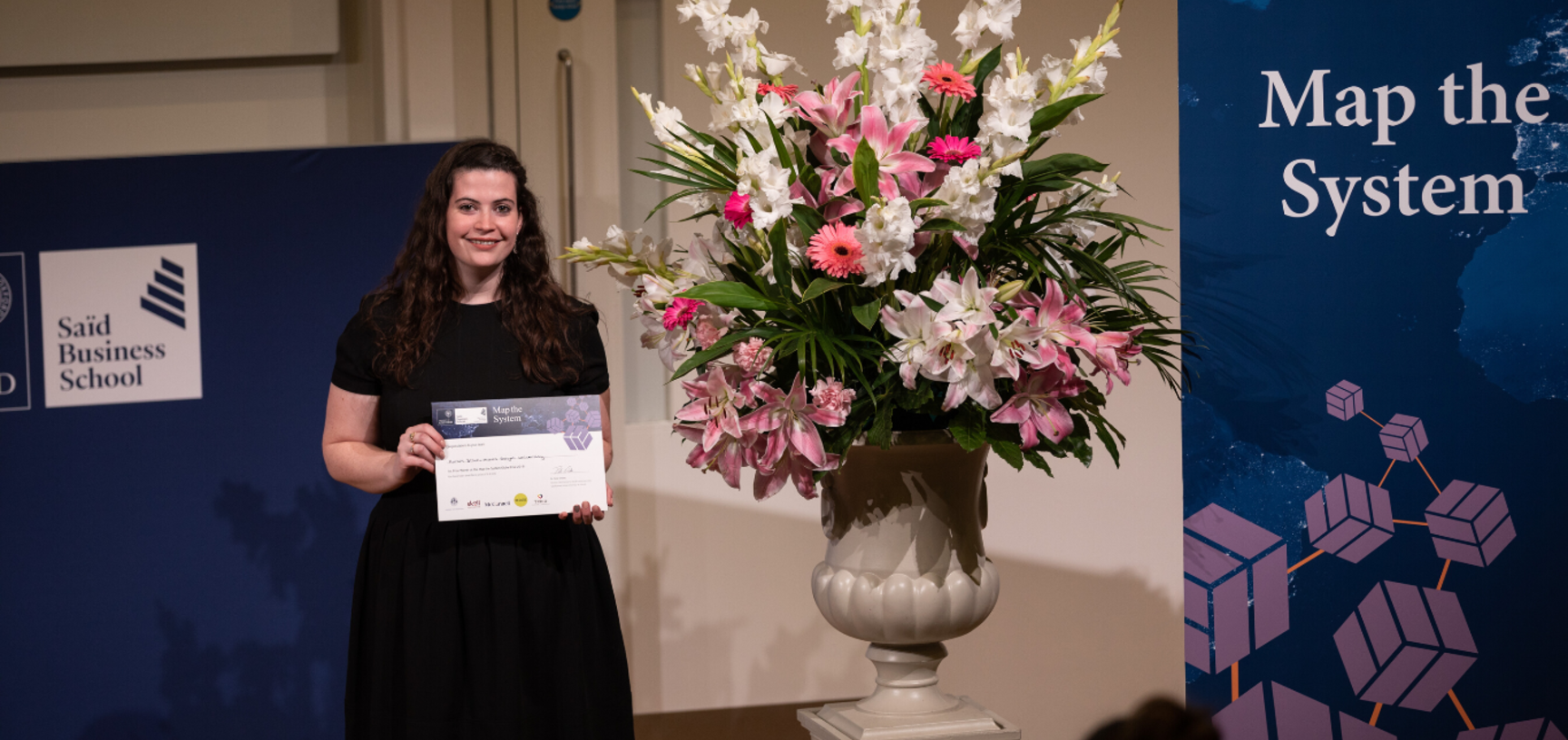 Roisin Dillon, Mount Royal University, holding Map the System 2018 Prize award