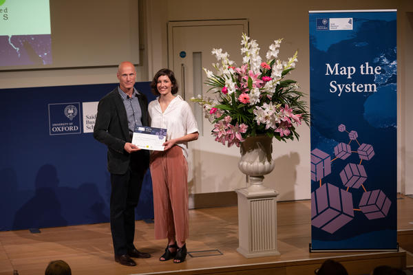 Dr. Abbey Eeles, University of Melbourne, holding Map the System 2018 prize award